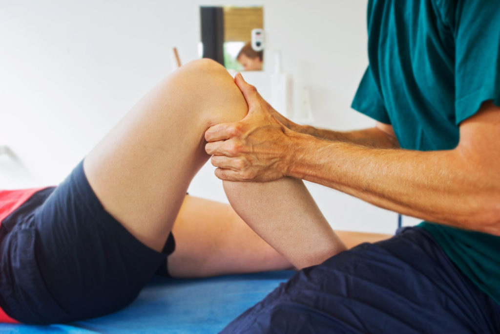 Arzt ueberprueft Knie auf Kreuzbandriss