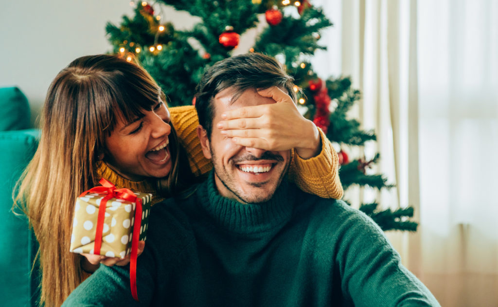 Frau überrascht Mann zu Weihnachten