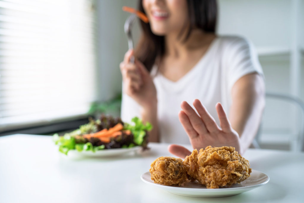 Frau isst Salat und verzichtet auf Gebackenes