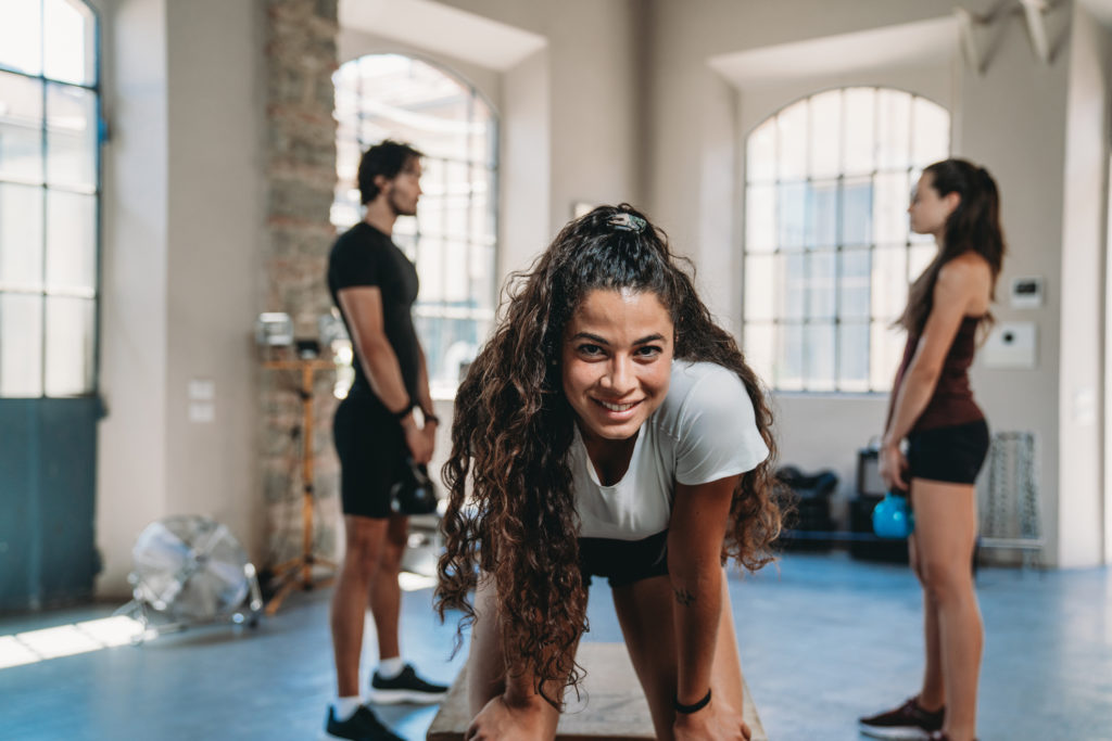 Zwei Frauen und ein Mann trainieren im Fitness Studio