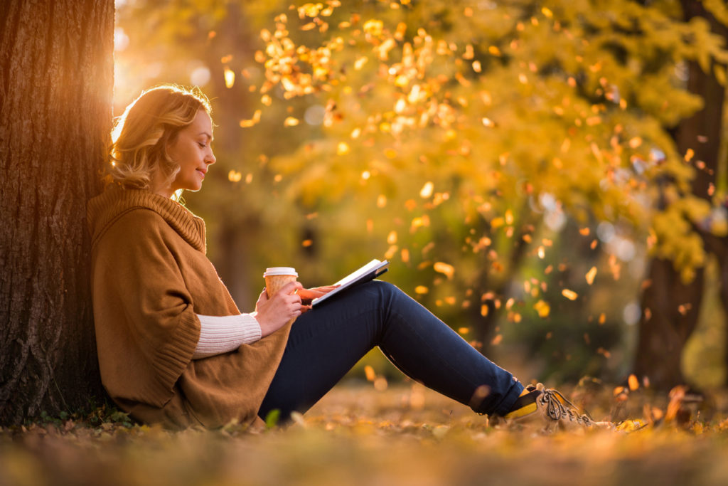 Frau sitzt im herbstlichen Wald