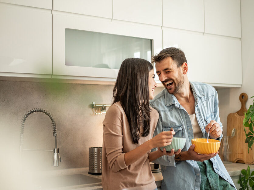 Glueckliches, gesundes Paar geniesst Essen in der K&uuml;che